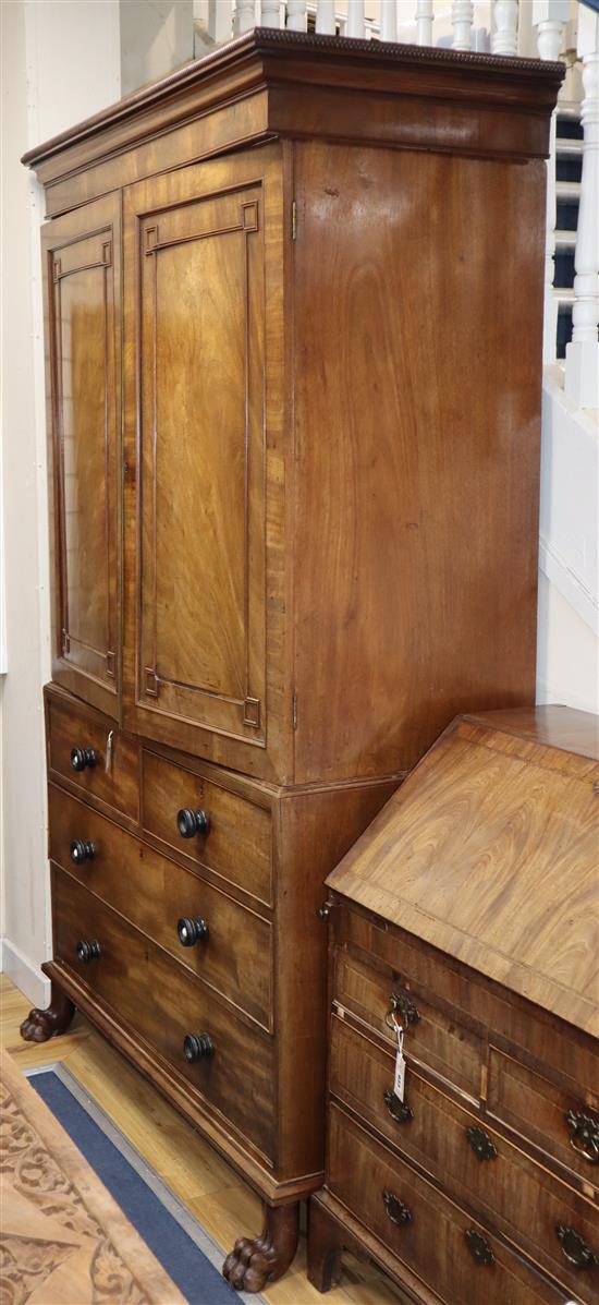 A Regency mahogany linen press having reel-turned cornice over a pair of doors enclosing trays, W.128cm